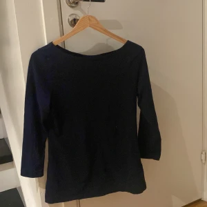 Mörkblå tröja med trekvartsärm - Säljer en stilren mörkblå tröja med trekvartsärm. Perfekt för både vardag och lite finare tillfällen. Den har en enkel och klassisk design som passar till det mesta. Skön och bekväm att ha på sig. Passar bra till höst och vår.