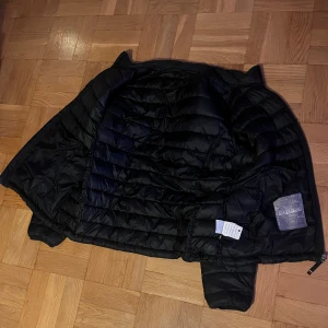 Svart Vinterjacka Napapijri - Säljer en svart vinterjacka Napapijri i ganska bra skick. Jackan har dragkedja framtill och två praktiska fickor. Perfekt för kyliga höst- och vinterdagar. Den är långärmad och har en normal passform. Storlek: XL-L Nypris: 4000kr 