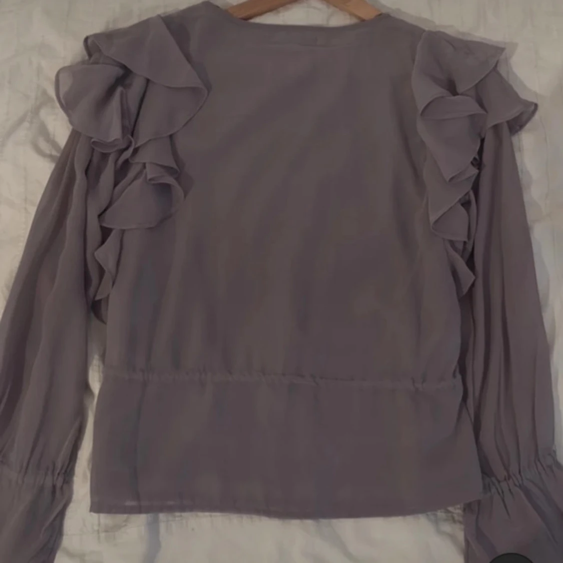 Lila blus med volangdetaljer