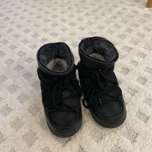 Svarta vinterboots från Inuikii - Säljer ett par svarta vinterboots från Inuikii i mycket bra skick. De är fodrade med mjukt material för extra värme och har en robust sula för bra grepp. Perfekta för kalla vinterdagar! Storlek 36. Nypris 3699