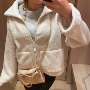 Vit teddyjacka med dragkedja - !inte mina bilder!!Mysig beige teddyjacka i syntetmaterial med dragkedja framtill. Perfekt för kyliga dagar, Jackan är supermjuk och stilren, idealisk för både höst och vinter. Ett måste i garderoben för den som älskar komfort och stil!