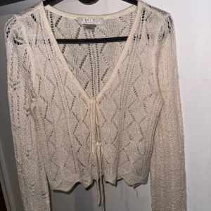 AMISU vit tröja, storlek XS  - En vit stickad tröja med långa ärmar och spetsmönster. Tröjan har en v-ringning 