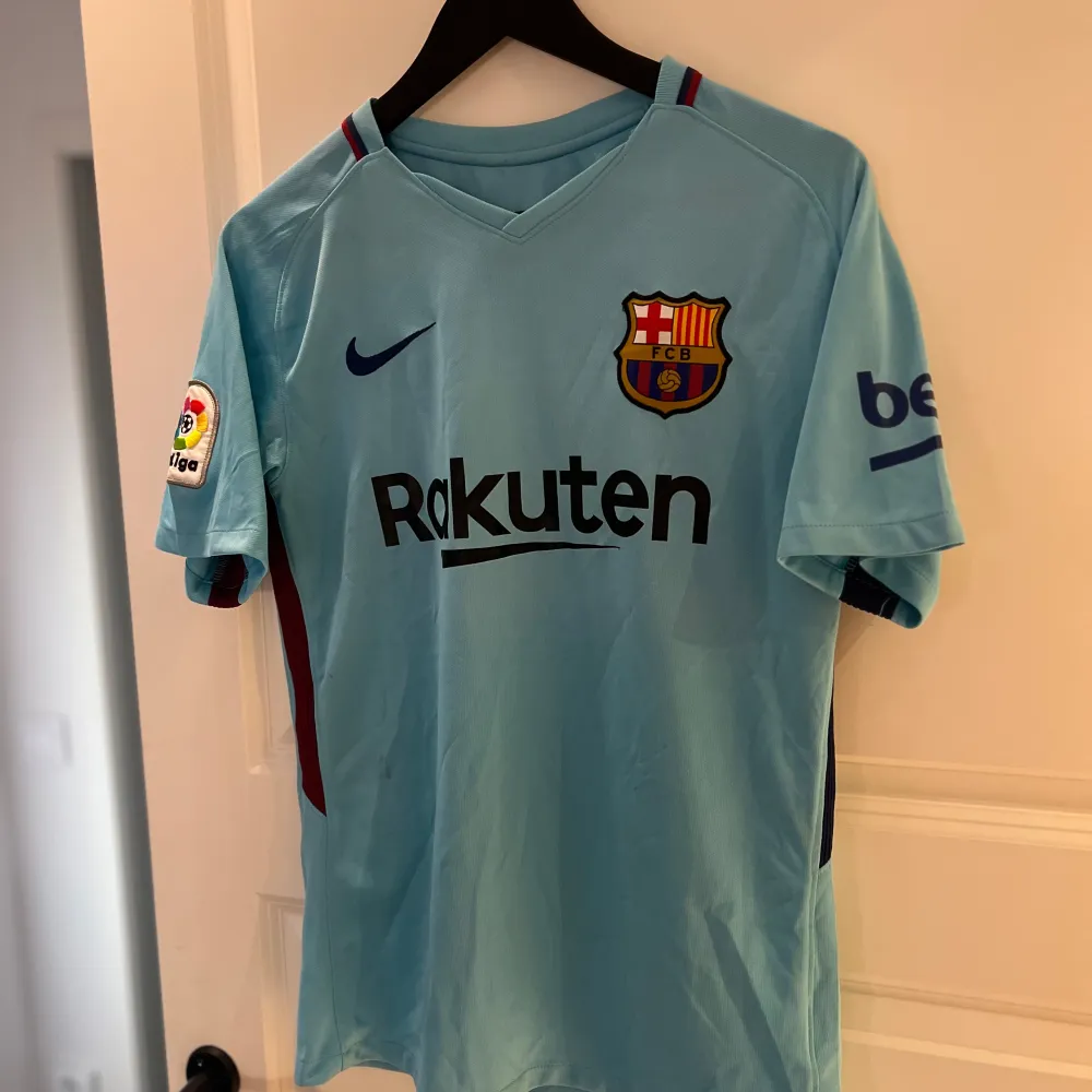 Säljer en ljusblå FC Barcelona tröja med Messi 10 på ryggen. Den har korta ärmar och La Liga-märke på ärmen. Rakuten-logga på framsidan och Unicef på baksidan. Perfekt för fans! 💙❤️. T-shirts.