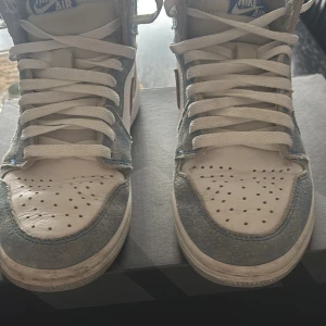 Nike Air sneakers i grått och vitt - Säljer ett par Nike Air sneakers i grått och vitt. De har en klassisk hög modell med snörning och perforerad tå för extra ventilation. Skorna är i bra skick med en ren design som passar perfekt till vardags eller träning. (Korrekta boxen saknas)