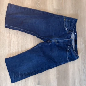 Blå jeans från Tiger of Sweden - Snygga blå jeans från Tiger of Sweden med klassisk femficksdesign och knappgylf. Perfekta för en stilren look.