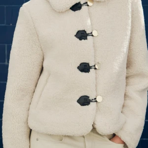 Beige teddyjacka från Zara - Mysig beige teddyjacka från Zara med svarta knappar. Är helt slutsåld på Zaras hemsida. Nypris 559kr. Passar perfekt nu till våren! Är i storlek M men passar perfekt till mig med storlek xs/s. Endast använd fåtal gånger och har inga tecken på användning