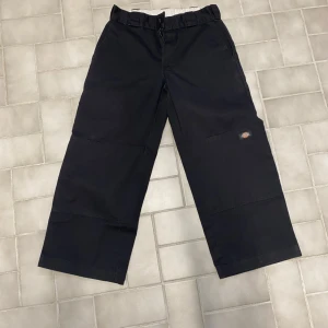 Svarta byxor från Dickies - Säljer ett par svarta byxor från Dickies med loose fit. Byxorna har en klassisk design med raka ben och en bekväm passform. Perfekta för en avslappnad stil. Byxorna är klippta och sedan proffesionellt omsytt i längden. Ny längd för dessa byxor är 86cm från toppen till botten
