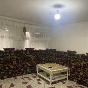 Stor hörnsoffa med blommönster, bord gardiner och matta för 6000kr - En stor hörnsoffa i mörkröd färg med ett detaljerat blommönster i gult och grönt. Soffan har en klassisk design med hög rygg och är perfekt för ett rymligt vardagsrum. Den ger en traditionell och inbjudande känsla till rummet.