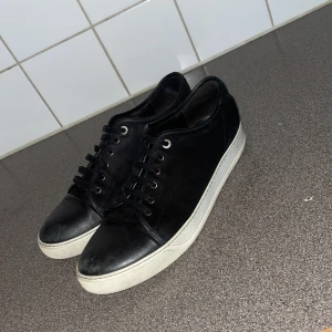 Lanvin - Snygga svarta sneakers med vit sula och klassisk snörning. Perfekta för en stilren look. 
