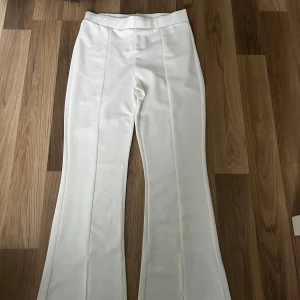 Vita byxor från Modas Bichai - Snygga vita byxor med hög midja och bootcut-stil från Modas Bichai. Perfekta för en stilren look med en skön passform. Byxorna har en slät design utan synliga detaljer som knappar eller dragkedja. Säljer då jag aldrig använt dom.🫶🏻Hör av er för mer frågor eller bilder.