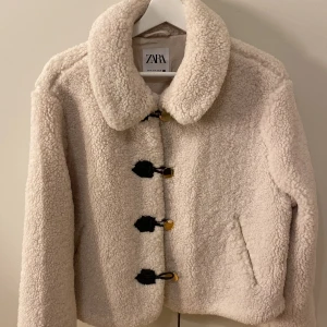 Beige teddyjacka från Zara - Super fin teddy jacka från zara med guldiga knappar. Den är helt oanvänd endast testad. Storlek M men passar för mindre med🩷