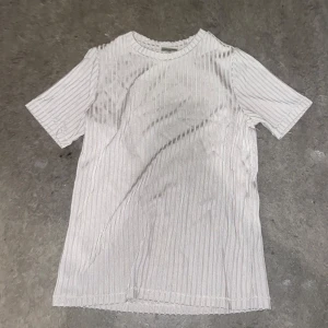 Vit ribbad t-shirt - Säljer en stilren vit ribbad t-shirt med korta ärmar. Perfekt för en avslappnad look. Passar bra till jeans eller shorts.