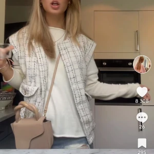 Väst från Holly &white - Snygg rutig väst i beige och svart. Västen har knappar framtill och praktiska fickor. Perfekt för att ge din outfit en stilren touch.