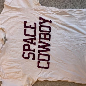 Vit t-shirt med texten 'Space Cowboy' från Ganni - Ganni. Finns ej o köpa.skit snygg