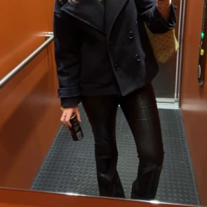 Svarta skinnbyxor - Snygga svarta skinnbyxor med en tight passform. Perfekta för en trendig look och kan stylas med olika toppar och skor. Det är små hål vid ”öglorna” men inget som syns och kan säkert fixas!!