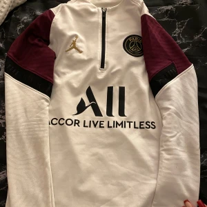 Vit Paris Saint-Germain tröja från Jordan - Snygg vit Paris Saint-Germain tröja från Jordan med vinröda och svarta detaljer.  Storlek S och sitter super snyggt! Använd ett fåtal gånger, skönt material och perfekt för fotbolls intresserade⚽️