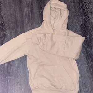 Beige hoodie från H&M - Säljer en stilren beige hoodie från H&M. Den har en klassisk design med en stor huva och en praktisk magficka. Perfekt för en avslappnad look.