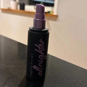 Urban Decay All Nighter Setting Spray - Säljer en Urban Decay All Nighter Setting Spray. Denna face mist kommer i en svart flaska med lila text och spraymunstycke. Perfekt för att hålla sminket på plats hela dagen och natten.