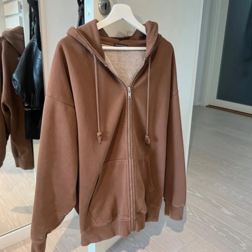 Säljer denna bruna zip up hoodie från brandy melville då den inte kommer till användning! Använd några gånger men är i jättebra skick ändå👍🏼 är i storlek oversize, passar bra som S-L🤎. Hoodies.