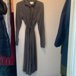 Midiklänning - Från Holly & Whyte Lindex Lite använd Midiklänning med spetskrage Knappar hela vägen Skärning ovanför midjan och skärp i samma tyg