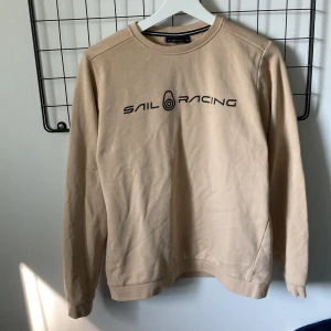 Sail Racing sweatshirt beige - Storlek 170 cm/XS knappt använd och tvättad en gång så tröjan är i nyskick. Köptes för 600 kr mitt pris 150 kr
