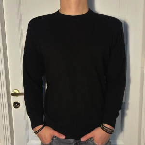 Svart Kaschmir Tröja från Oscar Jacobson - En Stilren Svart Kashmir tröja från Oscar Jacobson i storlek M. Tröjan är långärmad och har en klassisk passform. Tröjan är i utmärkt skick! Modellen är 182 cm och väger 75 kg. Priset är öppen till förhandling!