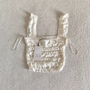 ZARA virkad vit topp - Virkad topp från ZARA i mjukt material. Ny med prislappar. Har en liten smutsfläck, toppen köptes så i butik men går säkert bort i tvätt.