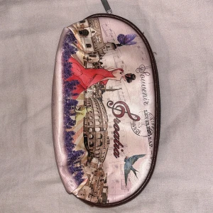 Necessär plånbok med tryck - Necessär med ett färgglatt tryck av en kvinna i röd klänning och kroatiskt motiv. Dragkedja upptill för säker förvaring.