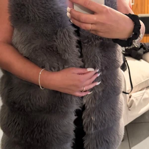 Grå pälsväst - Säljer en supermjuk och fluffig grå pälsväst. Perfekt för att hålla sig varm och stilren under kyliga dagar. Västen är i mycket bra skick och passar perfekt för höst och vinter. 