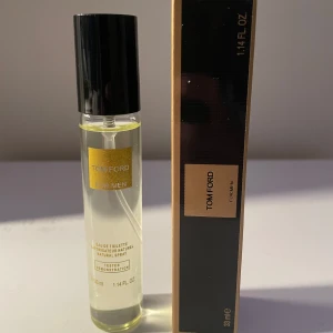 Tom Ford Eau de Toilette för män - Säljer en elegant Tom Ford Eau de Toilette för män. Flaskan är smal och genomskinlig med en svart kork och en gyllene etikett. Parfymen kommer i en stilren svart och guld kartong. Perfekt för den som vill ha en sofistikerad doft.