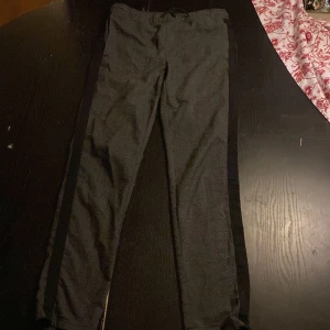 Grå rutiga byxor - Snygga grå byxor med diskret rutmönster. De har en slim passform och är perfekta för en stilren look. Byxorna är tillverkade i ett bekvämt material och har en elastisk midja för extra komfort.