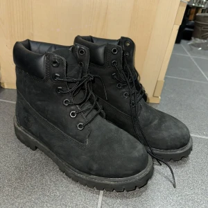 Svarta boots med snörning - Säljer ett par svarta boots med snörning och vadderad krage. De är tillverkade i mocka och har en robust sula, perfekt för kyligare väder. Hunter skor. Storlek 36-37