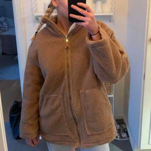 Beige teddyjacka med dragkedja och stora fickor framtill. En liknande modell till den trendiga teddyjackan från H&M.🤍