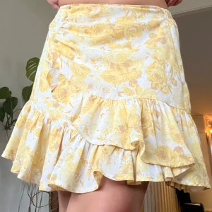 Gul blommig kjol med volang - Säljer denna somriga kjolen från Gina Tricot i storlek 34!💛Endast använd ett fåtal gånger. 