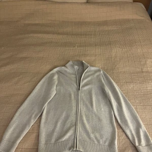 Grå fullzip dobber - Hej! Säljer nu denna stilrena fullzip från märket dobber som är kända för sin kvalité. Koftan är i storlek M och aldrig använd, nypris på tröjan är 899kr och mitt pris är 550. Vid frågor är det bara att skriva!
