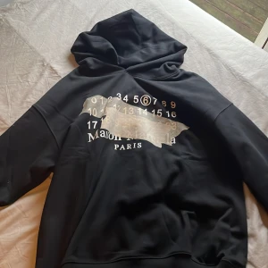 Svart hoodie från Maison Margiela - Säljer en svart hoodie från Maison Margiela, köpt för 5000kr passar inte mig perfekt. Mitt pris 3000kr. Priset går att fixa vid snabb affär 