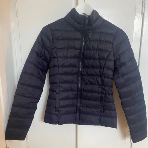 Svart pufferjacka - Marinblå tunnare variant pufferjacka, passar perfekt under skaljacka i skidbacken bland annat…