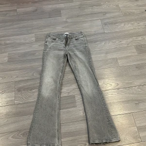 Grå bootcut jeans - Snygga grå bootcut jeans med klassisk femficksdesign och dragkedja. 