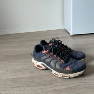 Nike air Max tn strl: 43 - Snygga blå sneakers med en robust beige sula och svarta snören. Skorna har en unik design med orange detaljer och en luftig ovandel. Perfekta för en avslappnad stil.