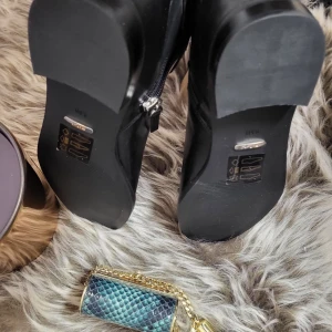 Svarta stövlar med dragkedja från Ralf lauren  - Snygga svarta stövlar i skinn med dragkedja och dekorativt spänne. Perfekta för höst och vinter, dessa stövlar har en klassisk design med spetsig tå och hög skaft. Aldrig använt..I storlek 40 ...pris: 1200 kr