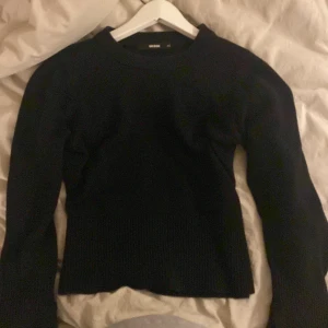 Svart stickad tröja från BikBok - Säljer en svart stickad tröja från BikBok i storlek XS. Den är supermjuk och perfekt för kyliga dagar. Tröjan har långa ärmar och en klassisk rund halsringning. Passar både till vardags och lite finare tillfällen. Ett måste i garderoben! 🖤