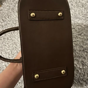 Brun rutig handväska  - Säljer en elegant brun rutig handväska. Väskan är fejk.  Perfekt för både vardag och fest! Köparen står för frakten. Pris kan diskuteras!