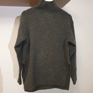 Grå stickad polotröja från H&M - Mysig grå stickad polotröja från H&M i storlek S. Perfekt för kalla dagar med sin höga krage och långa ärmar. Den är i lite längre modell så riktigt snygg till tighta byxor, midikjol eller tights! Slits (eller vad det nu heter?) i sidorna 🌟 polokragen har ett snitt så man slipper strypkänslan haha 
