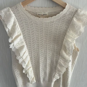 Vit stickad topp från Holly & Whyte - Säljer en söt vit stickad topp från Holly & Whyte med volangdetaljer på axlarna. Toppen är som ny och säljs inte längre i butik!🩷