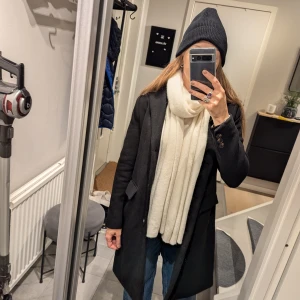 Svart kappa, ullmix i mycket bra skick.  - Säljer en stilren svart kappa i mycket bra skick. Den har en klassisk design med knappar framtill och långa ärmar. 