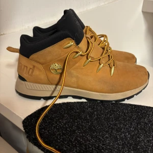 Bruna kängor från Timberland strl 43 - Sparsamt använda i en säsong. Strl 43  Nedan står att läsa om dem.   Sprint Trekker Chukka är vinterkängorna som kommer komplettera din look när temperaturen sjunker. De har en ovandel i nubuckskinn som garvats med hållbara metoder och innerfoder i ReBOTL-material som består av minst 50% återvunnen plast. De är utrustade med en mjuk och stödjande innersula för optimal komfort samt en stötdämpande EVA-mellansula. Yttersulan i gummi garanterar dig ett bra grepp på underlaget.