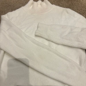 Vit stickad polotröja - Mysig vit stickad polotröja med långa ärmar. Perfekt för kyliga dagar och ger en stilren look. Passar bra till både jeans och kjol. Den har ett litet hål i ärmen men inget man lägger märke till, annars som ny!🤍🤍