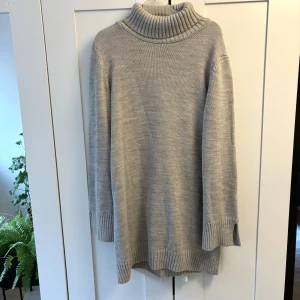 Beige stickad polotröja - Mysig grå stickad polotröja från Trendyol med ribbade detaljer. Tröjan har små slitsar vid handledarna. Köpt på Zalando! Perfekt för kyliga dagar med sin långa passform och långa ärmar. Kan bäras med byxor eller som en klänning 💕