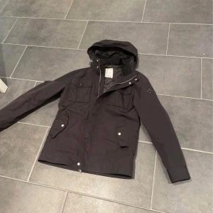 Svart J.Lindberg Jacka - Säljer en svart J.Lindberg jacka i storlek M. Den är i jättefint skick! Nypris är 3700kr och säljer denna för 1200kr. Hör av dig vid frågor eller funderingar!