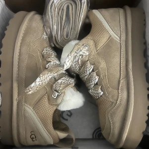 Beige boots  UGGs - Säljer ett par beige boots från UGG med snörning och mjukt foder. Dom är helt nya och oanvända i orginalförpackning